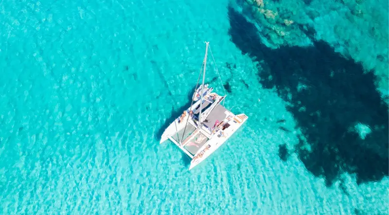 Aerial view of a boat on the turquoise water of the Bay of Kotor